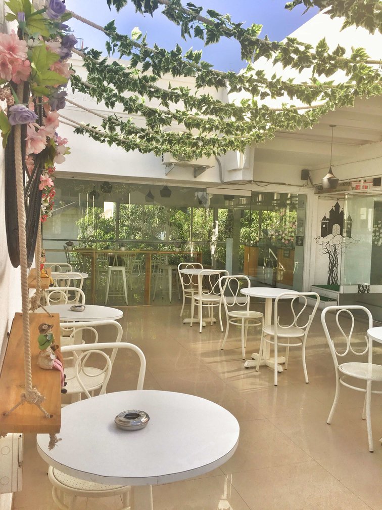 Beans Talk Cafe- open-air garden chairs with rustic decor & a canopy of vines strewn overhead